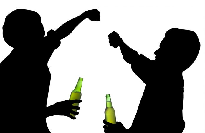 Silhouette drunk men fights while holding a bottle of beer